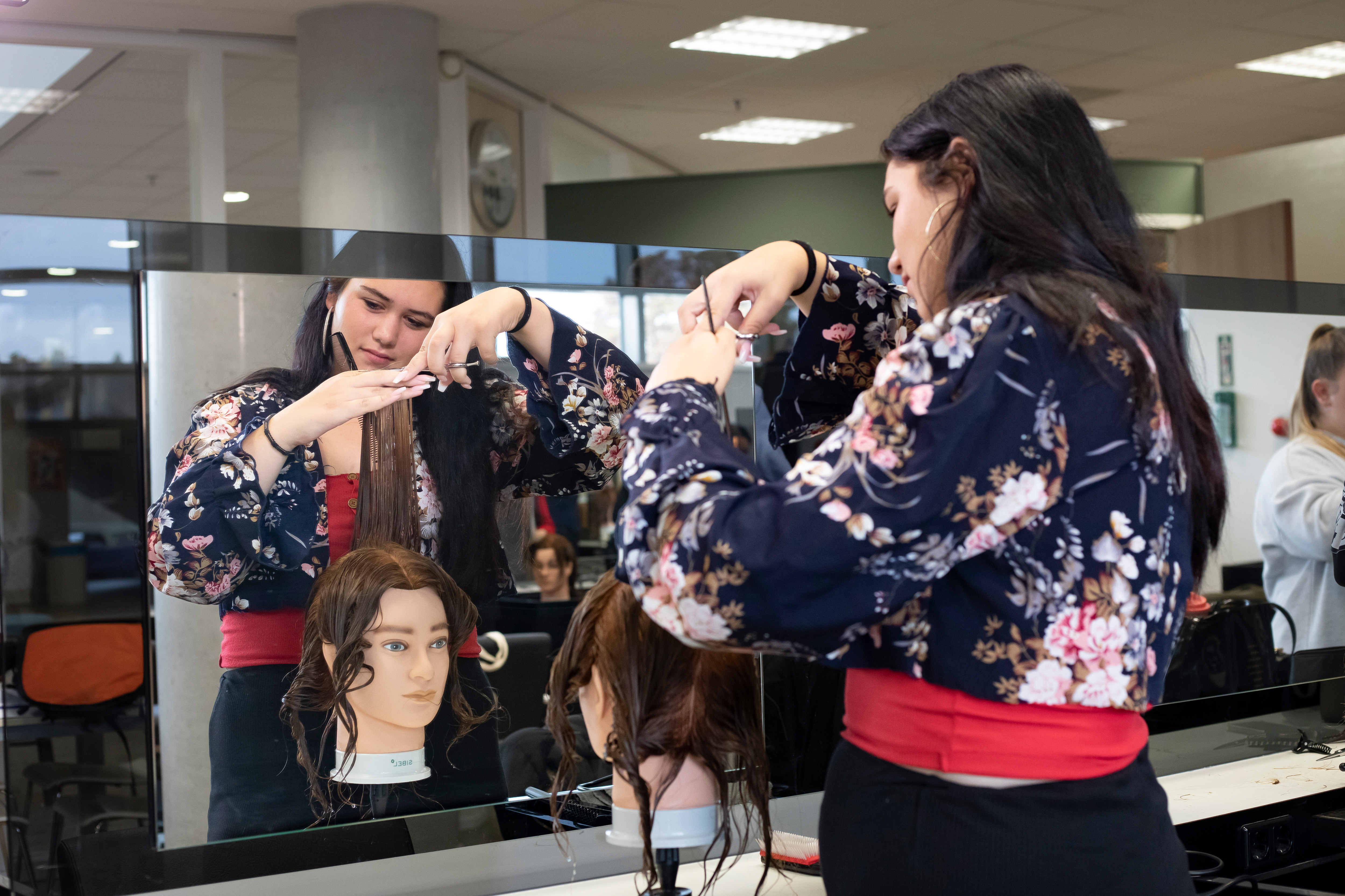 Student knipt een paspop en staat voor de spiegel