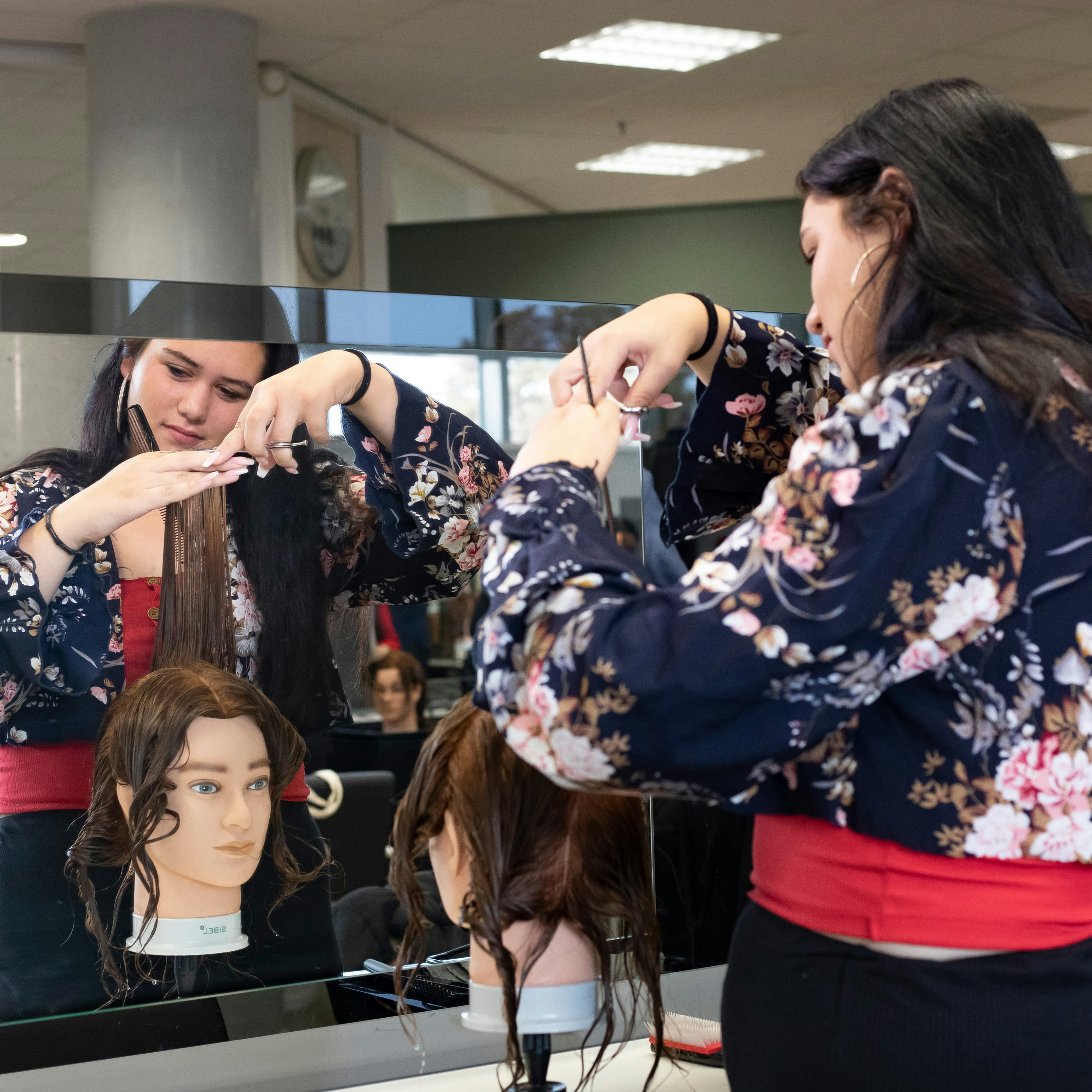 Student knipt een paspop en staat voor de spiegel