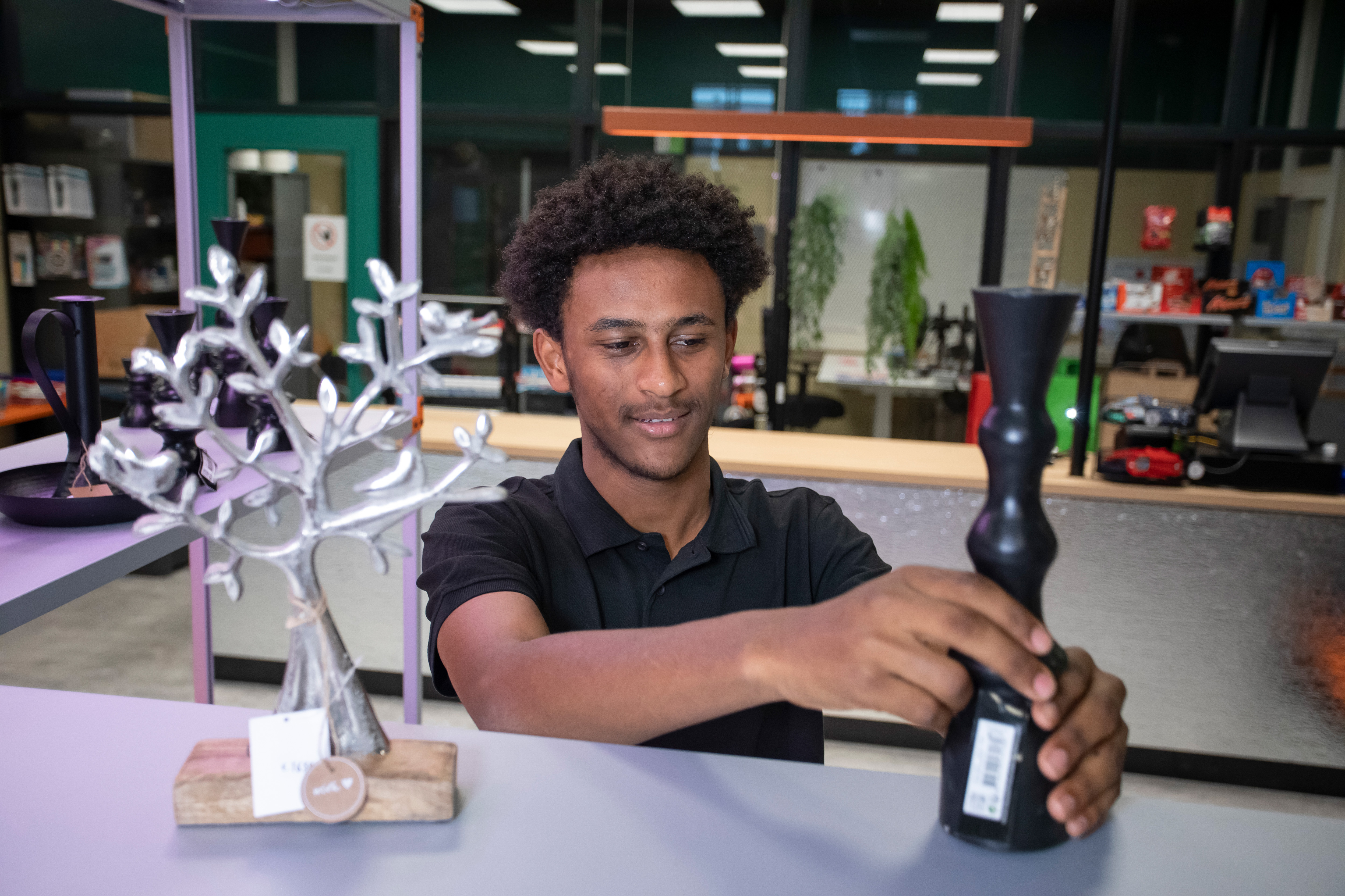 Student zet een kaars op een schap in de winkel