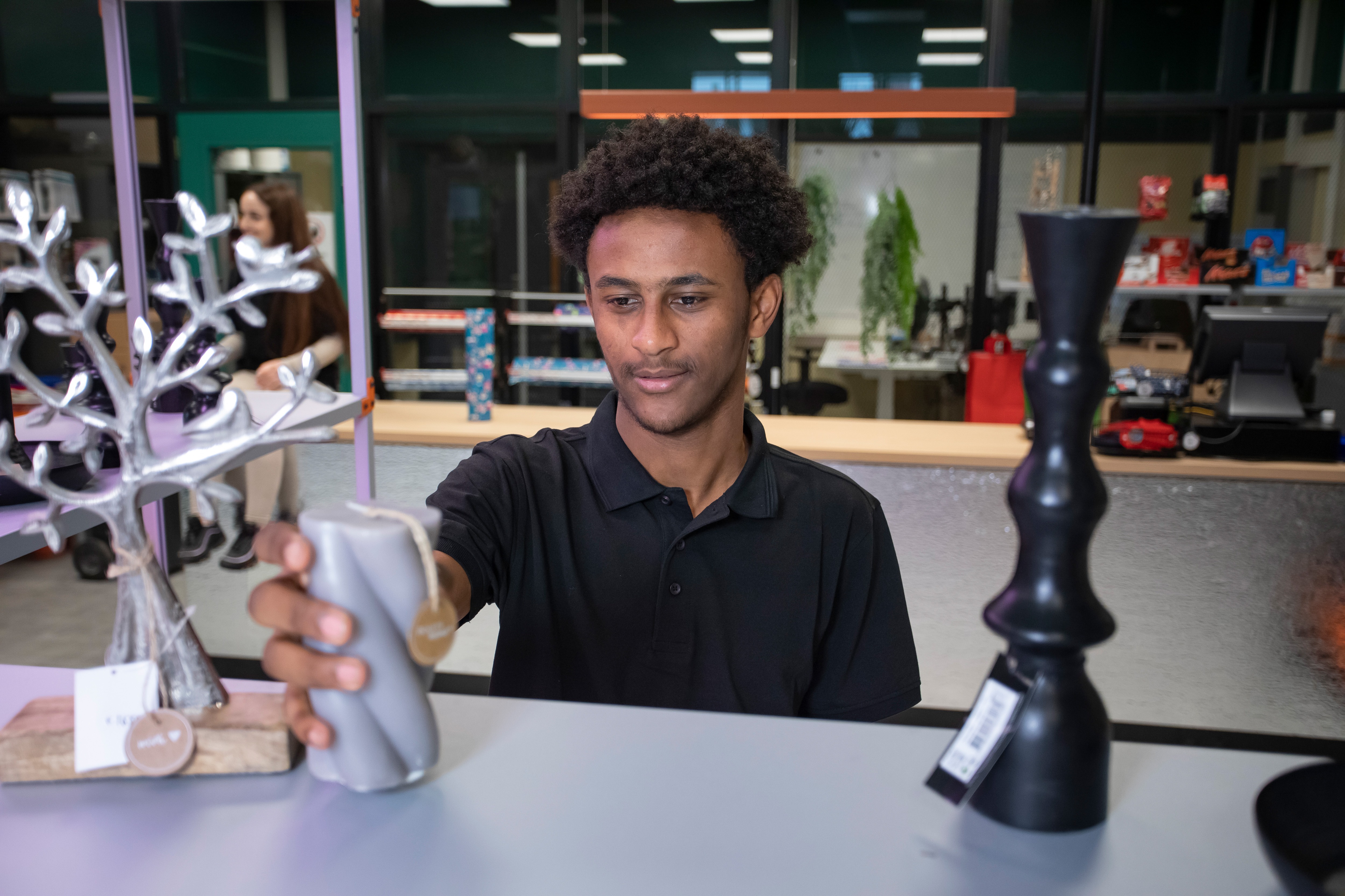 Student zet een kaars op een schap in de winkel