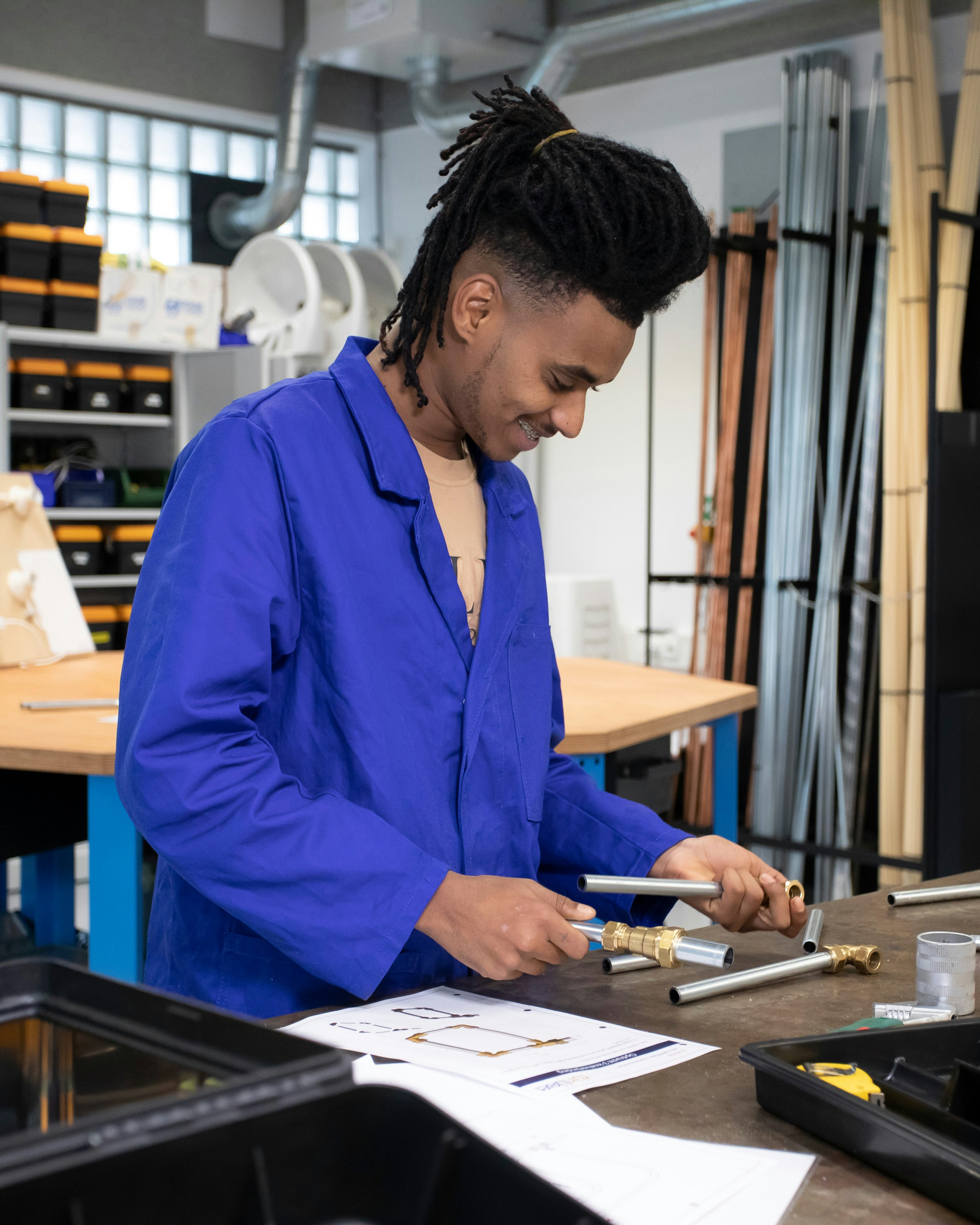 Student is bezig in de werkplaats met buizen