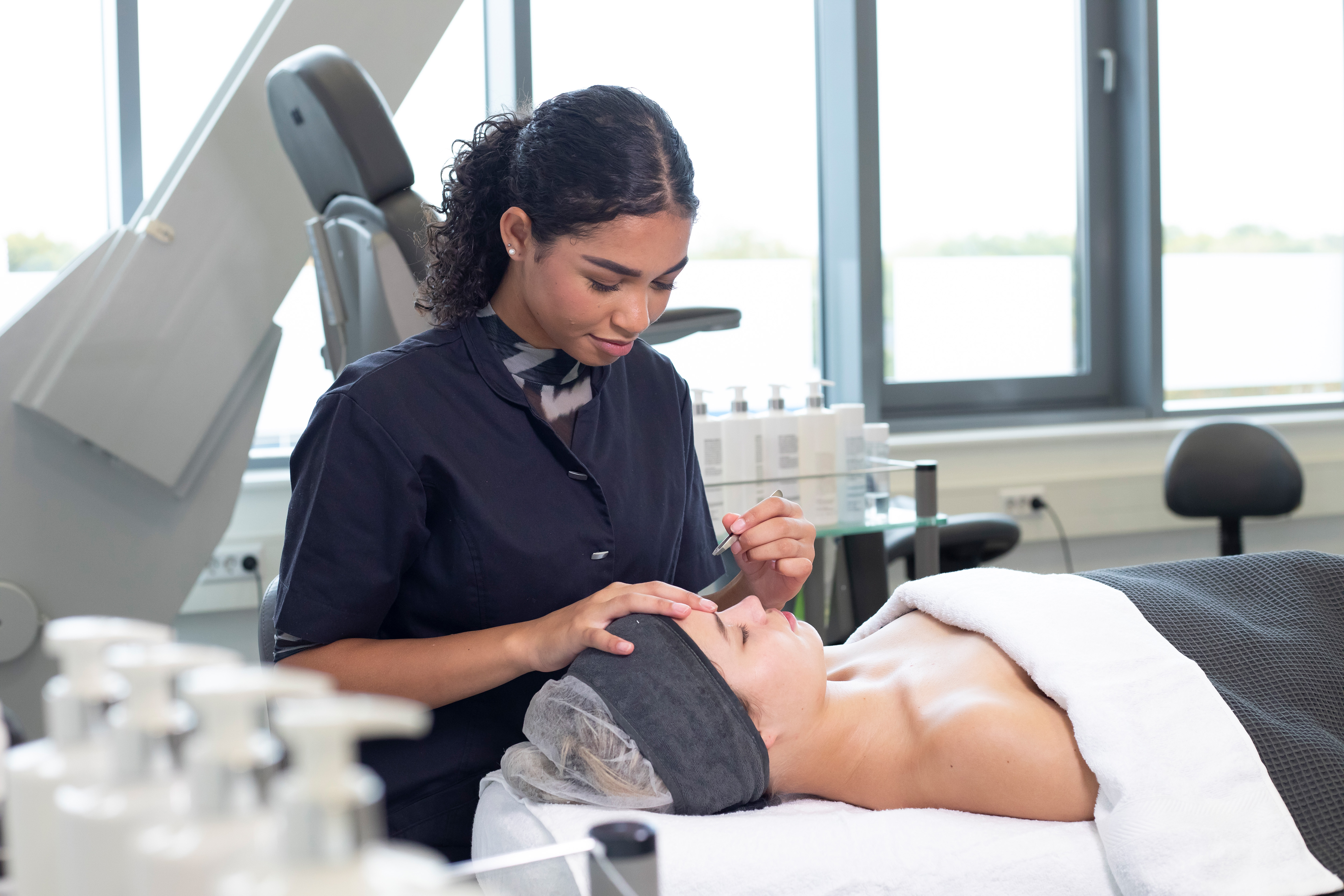 Student is bezig met de wenkbrauwen van een klant
