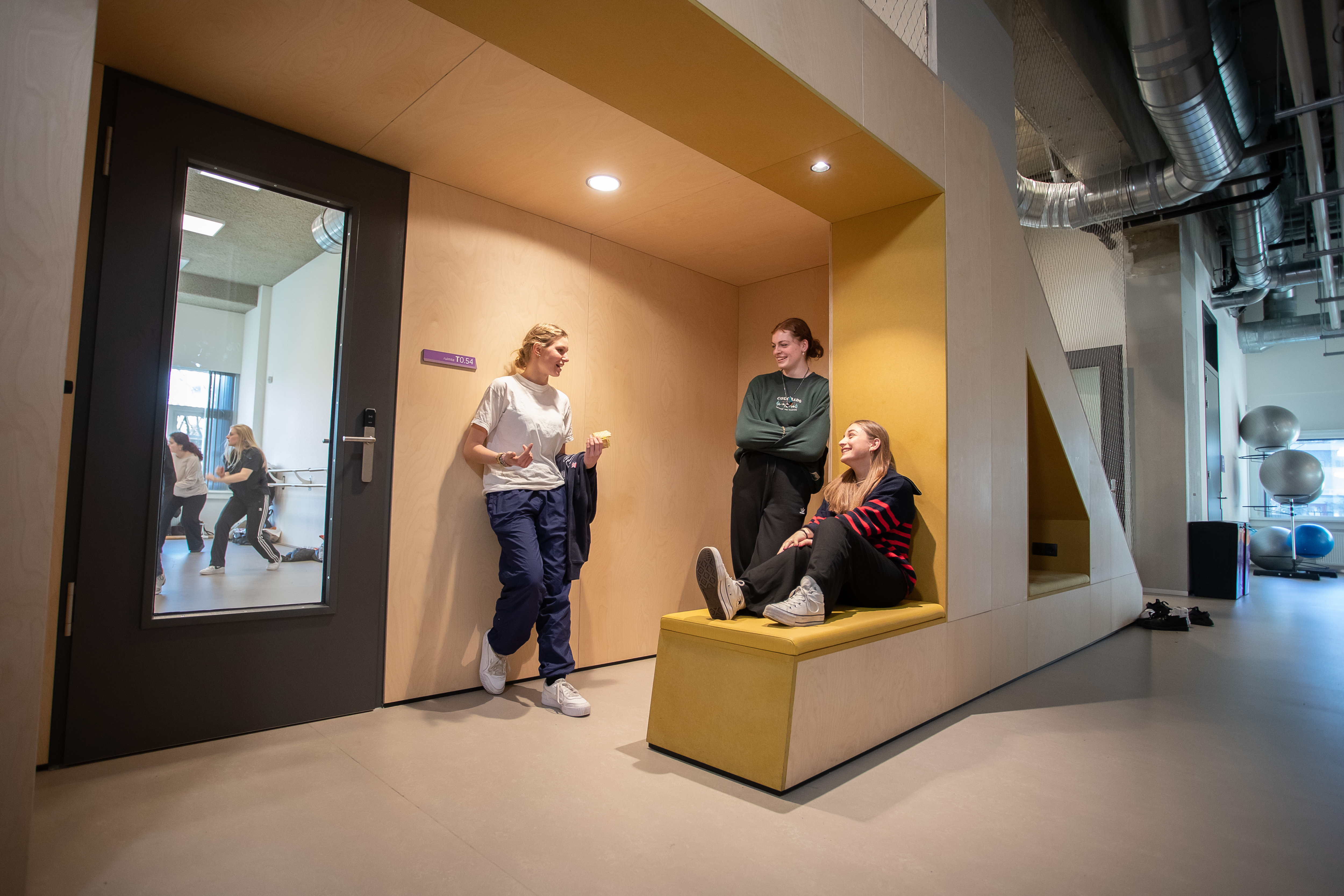 3 studenten zitten te wachten voor een lokaal