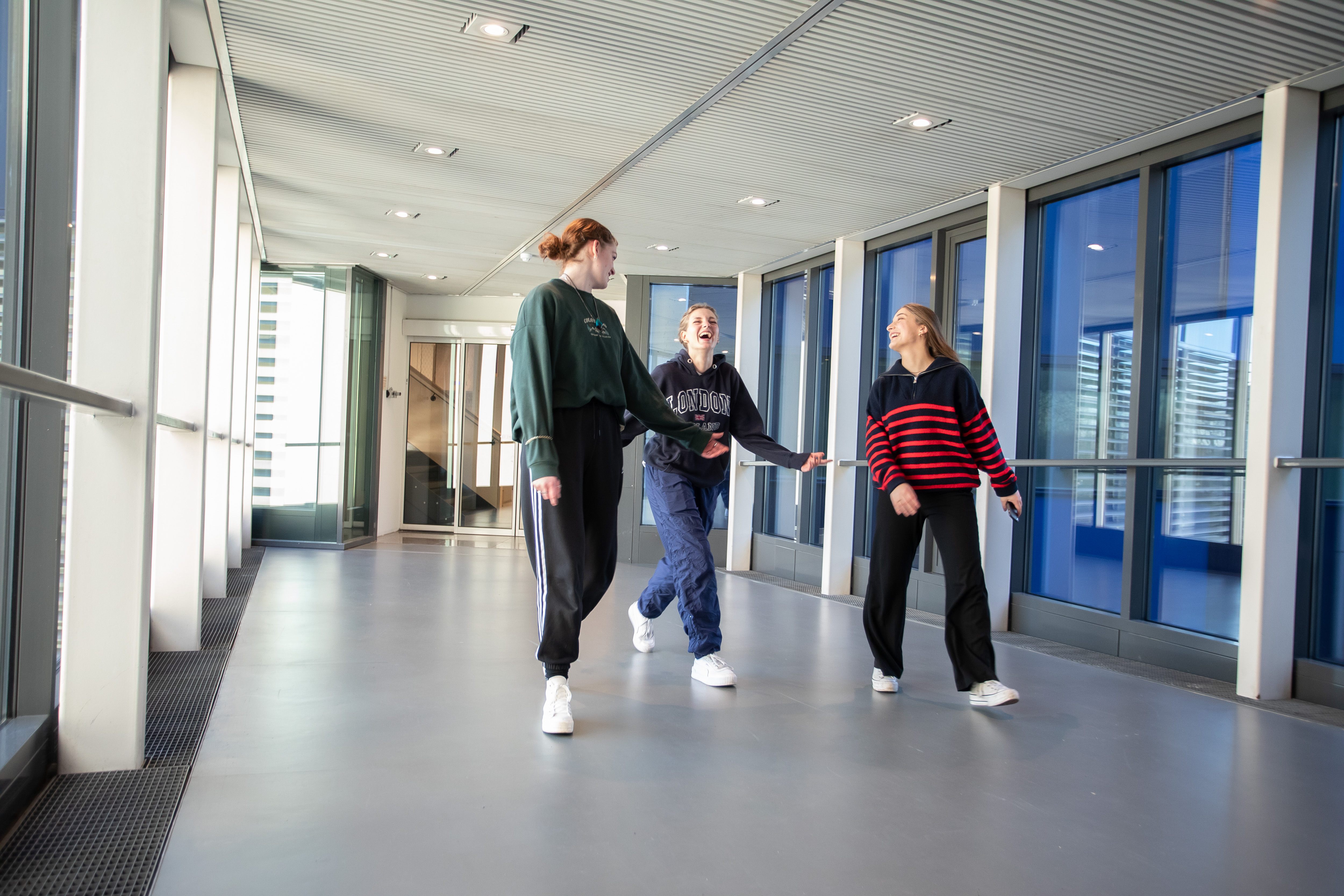 3 studenten lopen in de gang