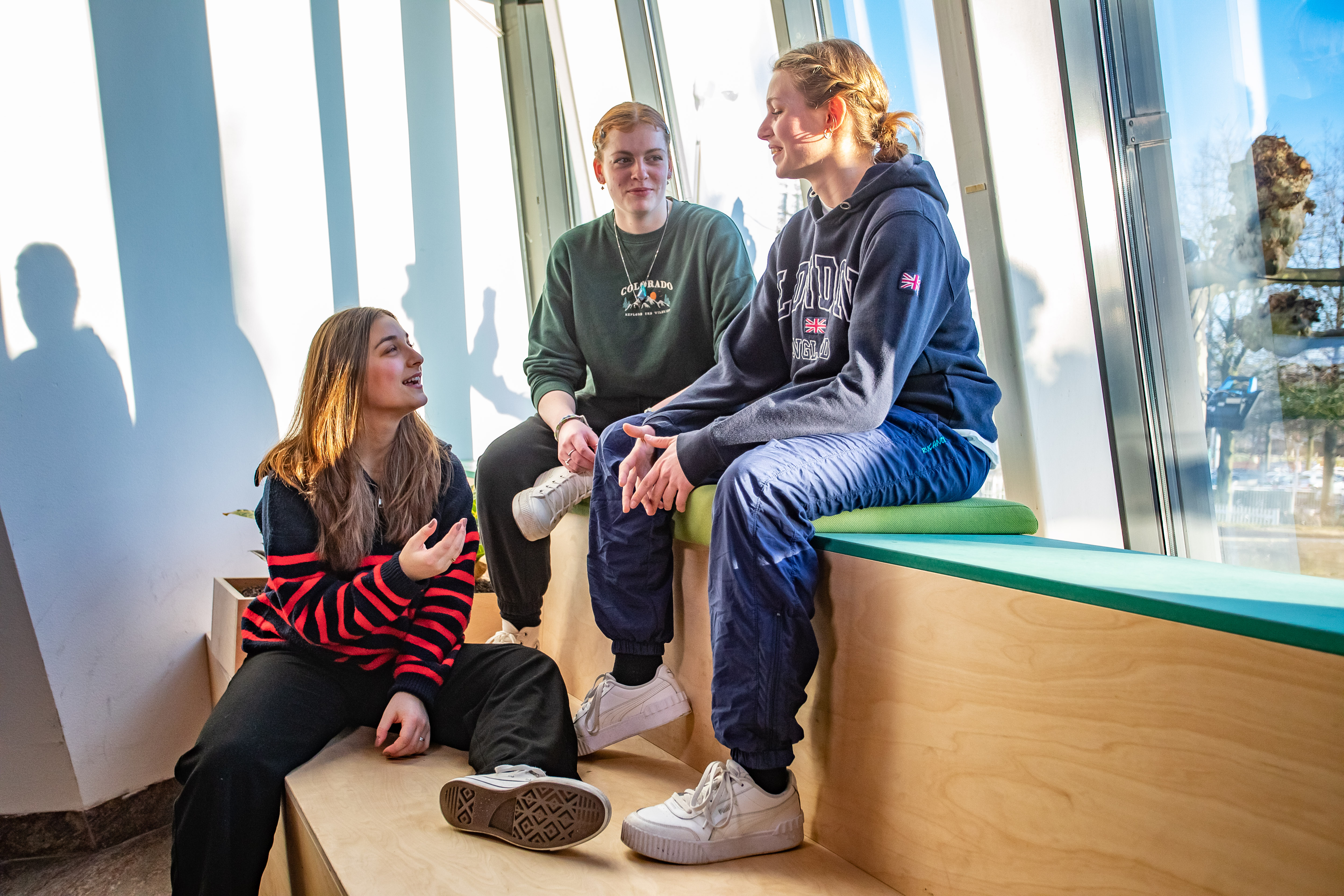 3 studenten zitten op een bankje