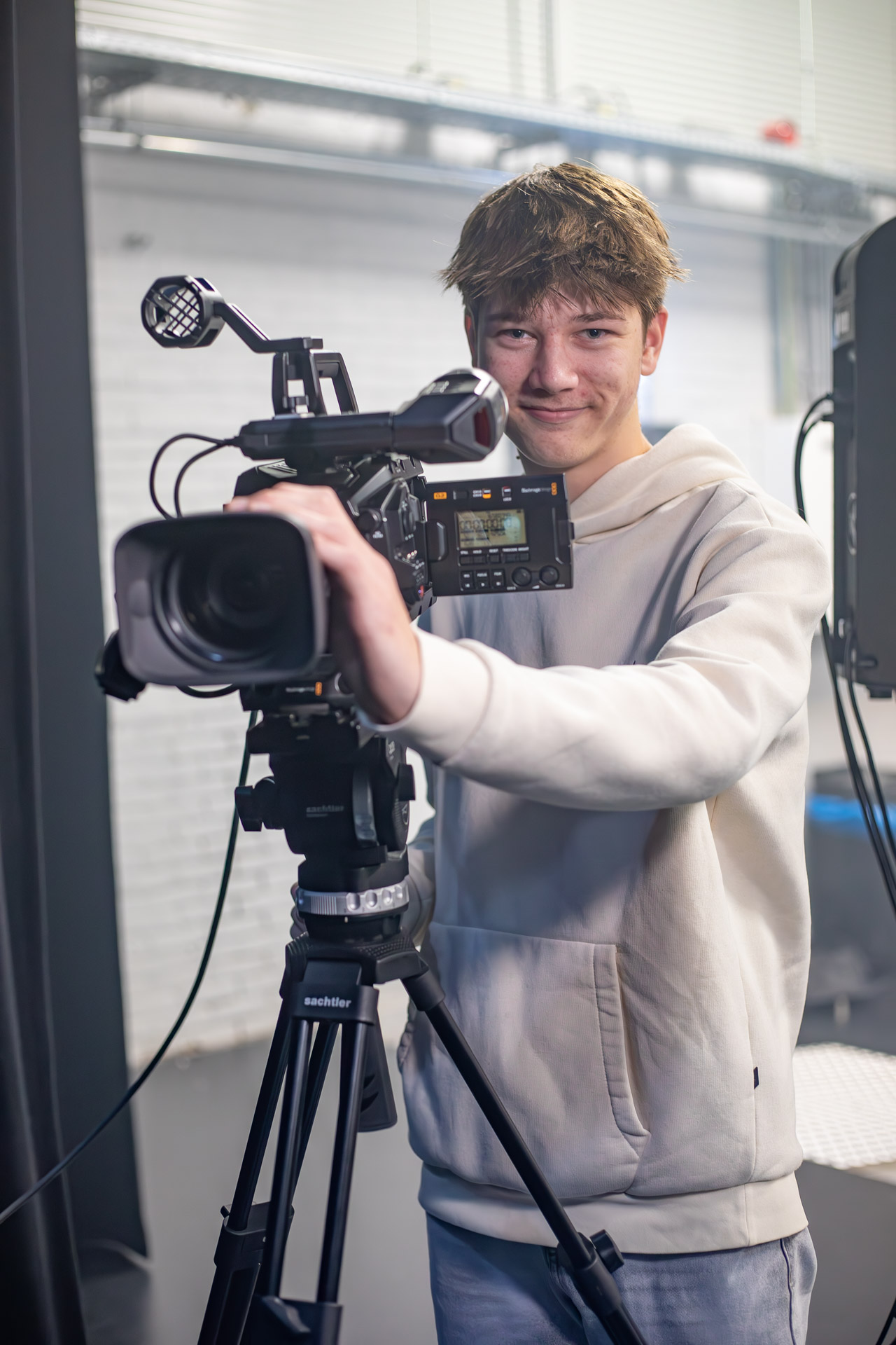 Student staat achter een camera op statief