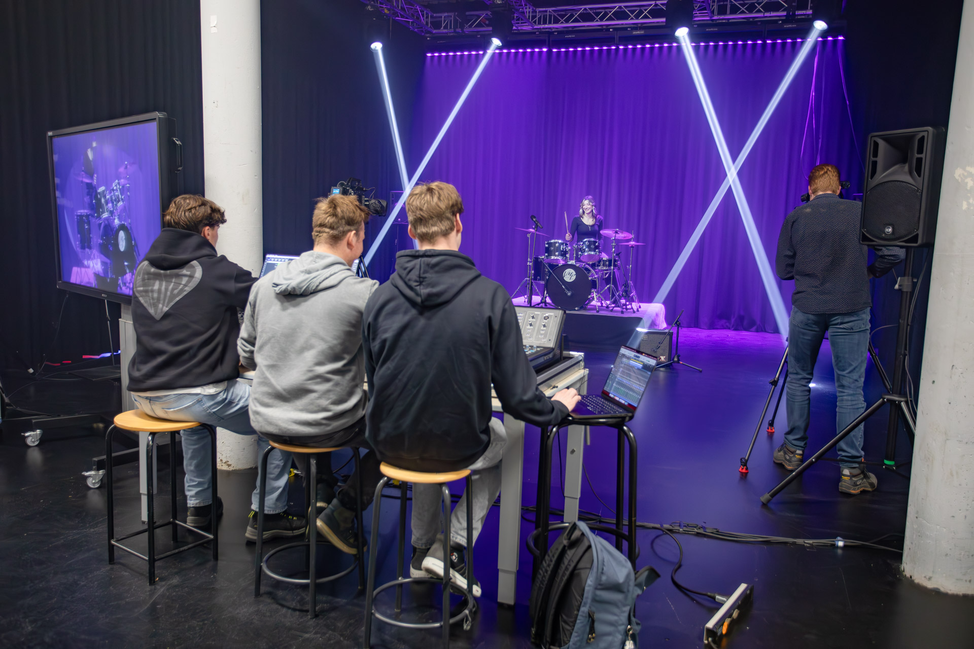 Student zit achter een microfoon met een koptelefoon op