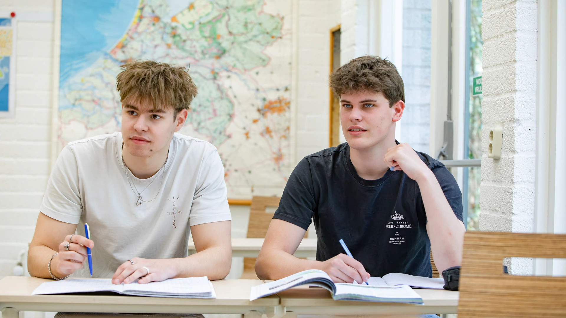 Twee jongens in een klaslokaal en kijken weg van de camera.