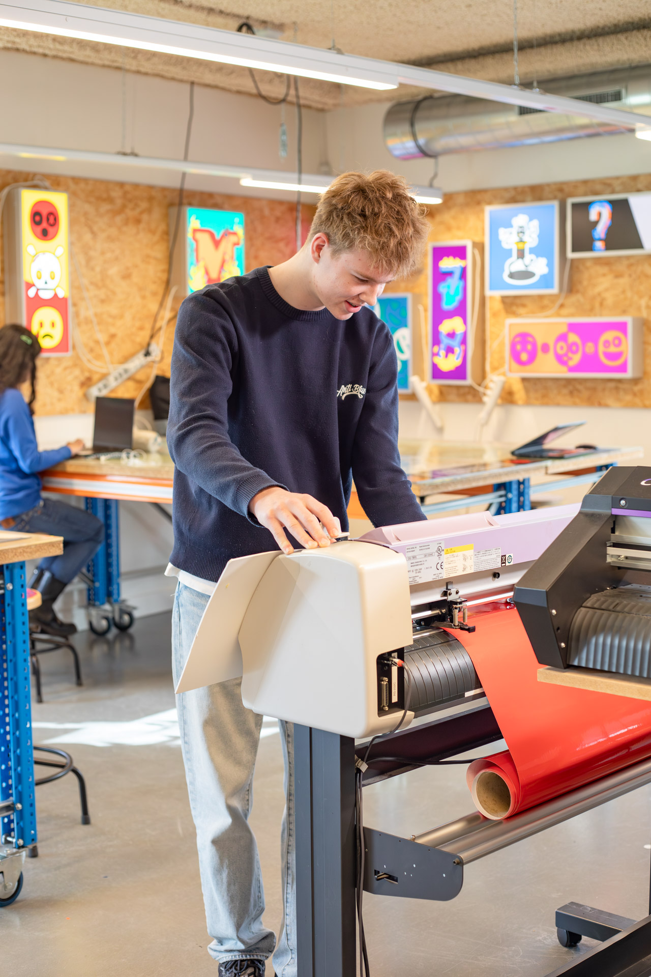 Een jongen een machine aanzet.