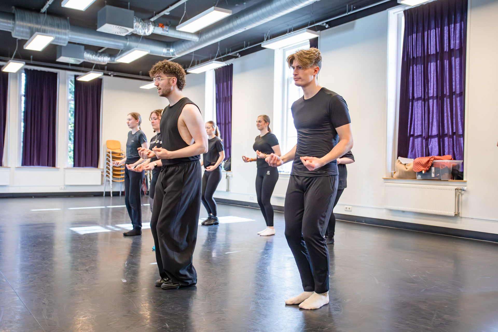 Zes studenten in een danslokaal dansen.