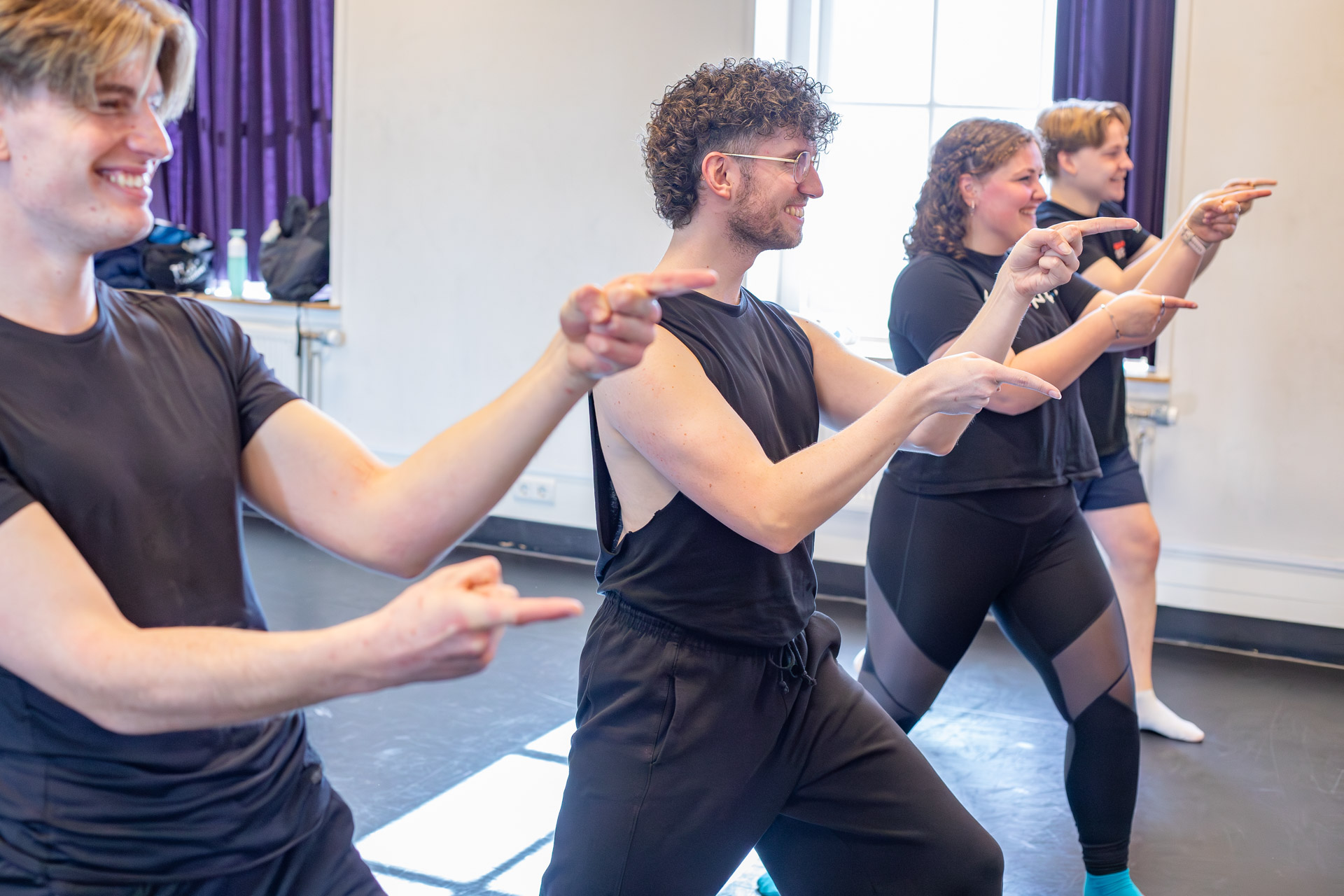 Drie studenten die dansen in een danslokaal.