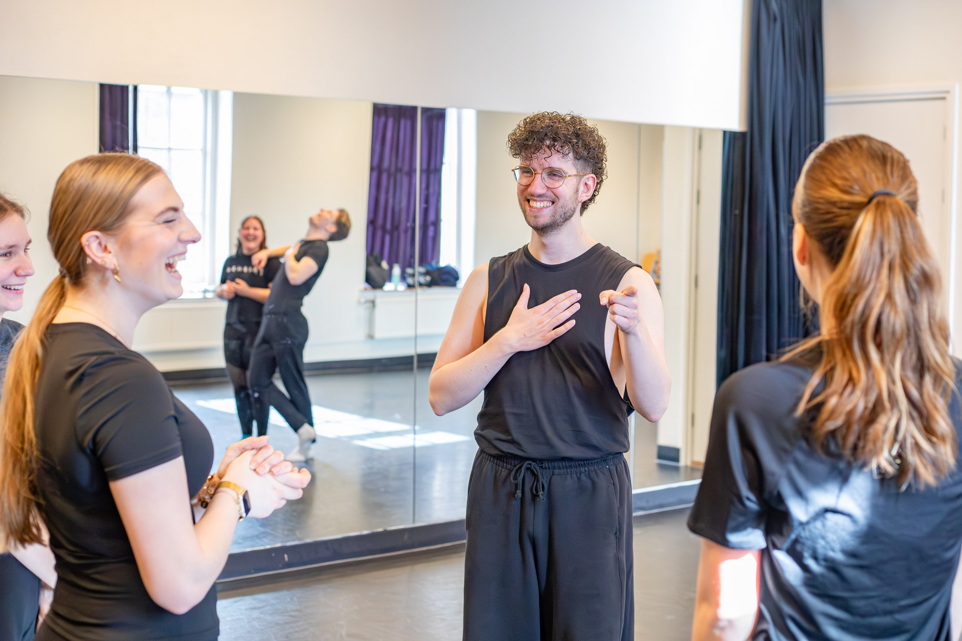 Studenten in een danszaal die lachen met elkaar.