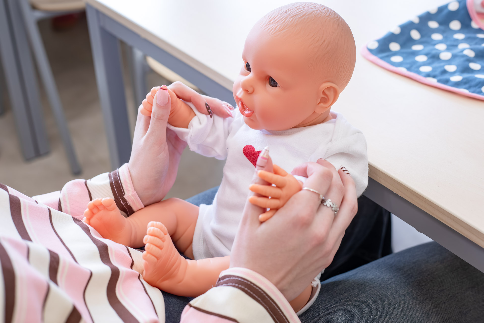 Je ziet een babypop op de schoot van een persoon