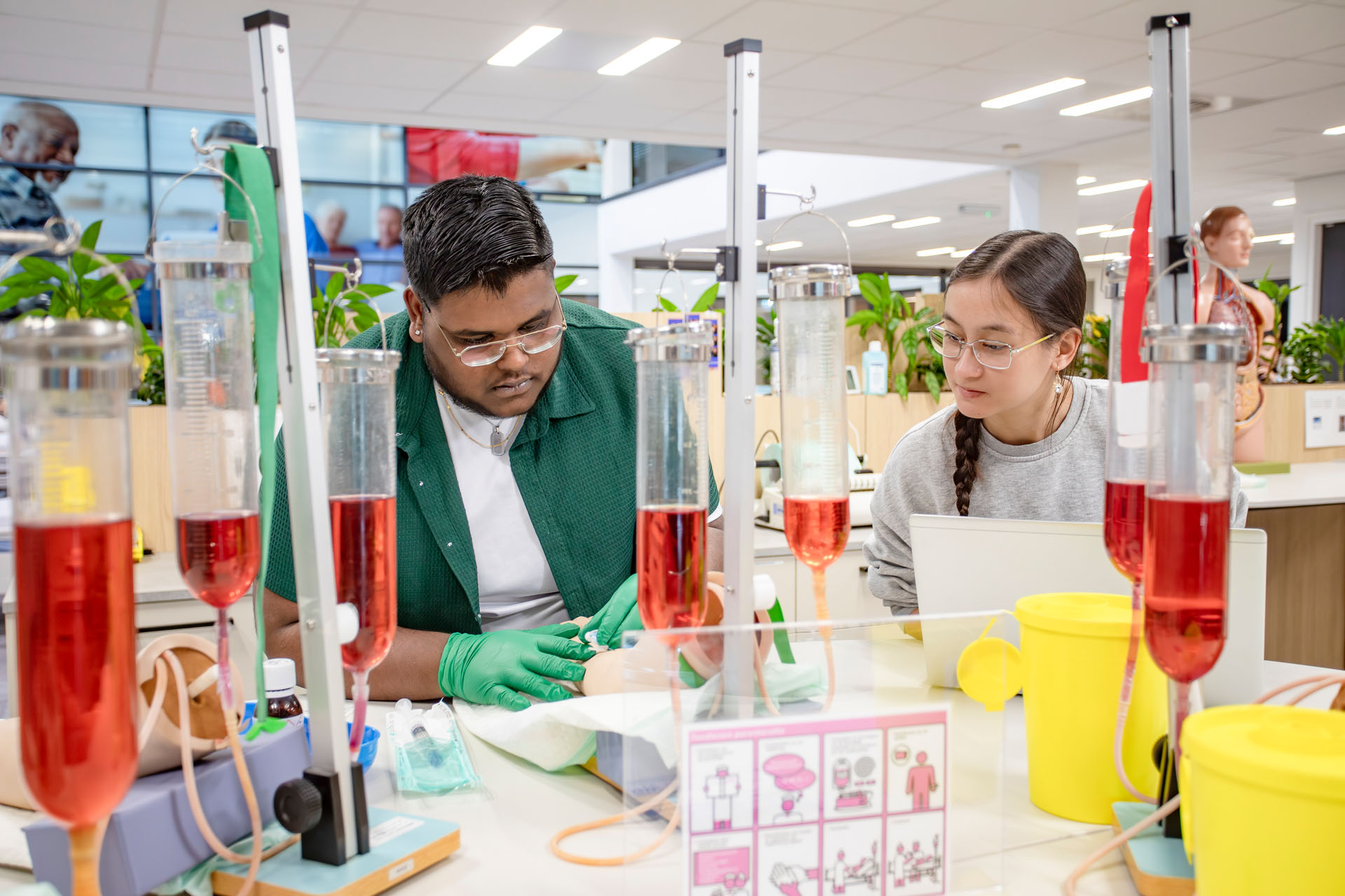 Jongen met handschoenen aan gaat bloedprikken terwijl een meisje toekijkt.