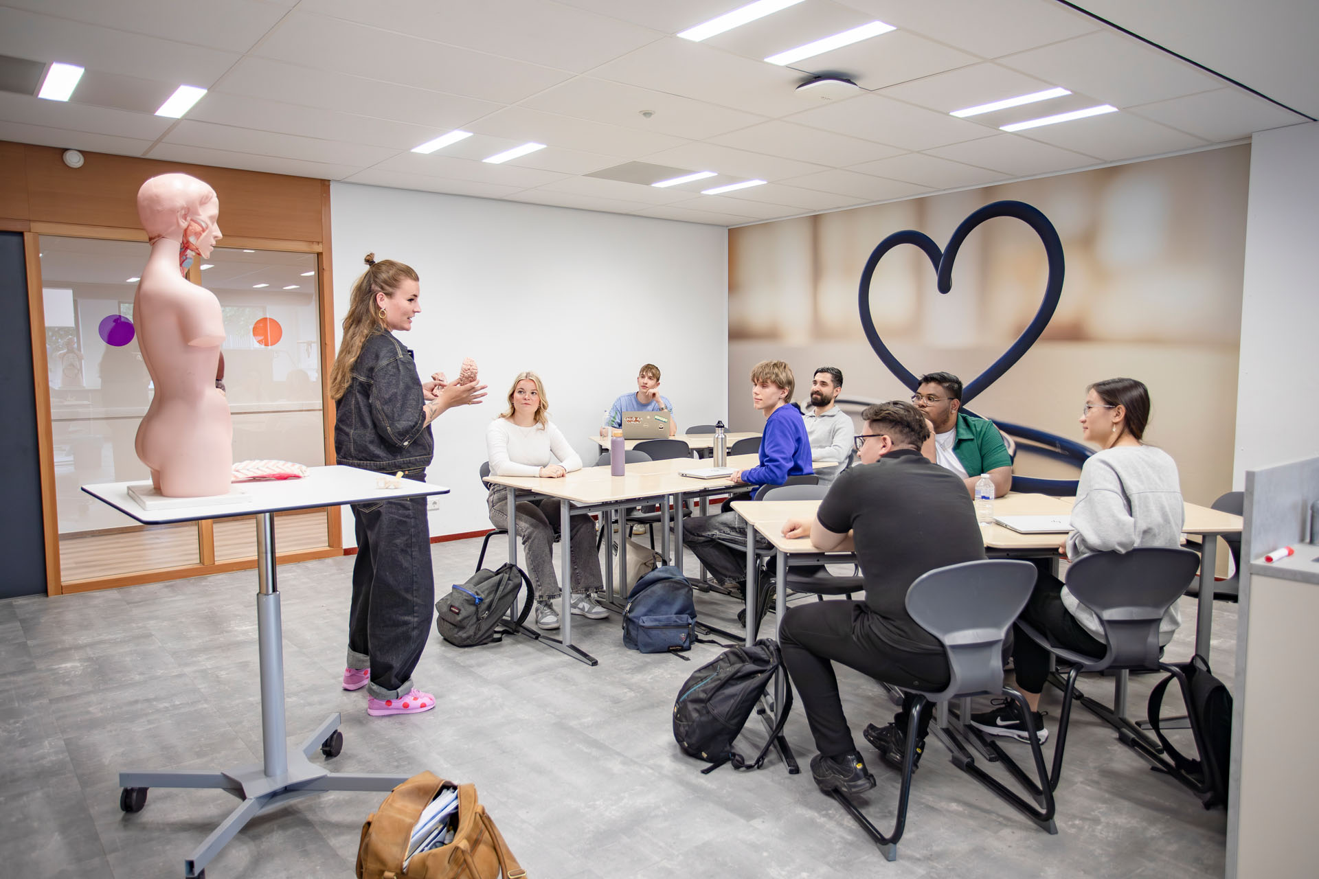 Een docent staat voor een klas instructie te geven.