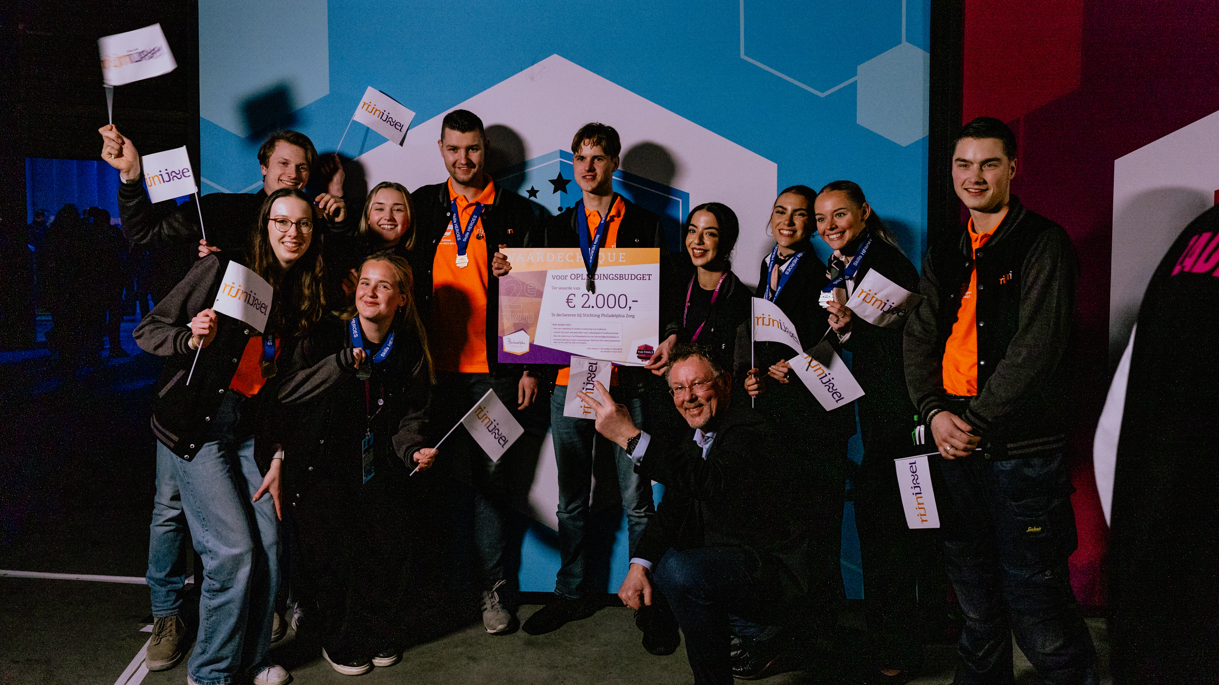 Groep studenten poseert voor de foto met een cheque in hun hand