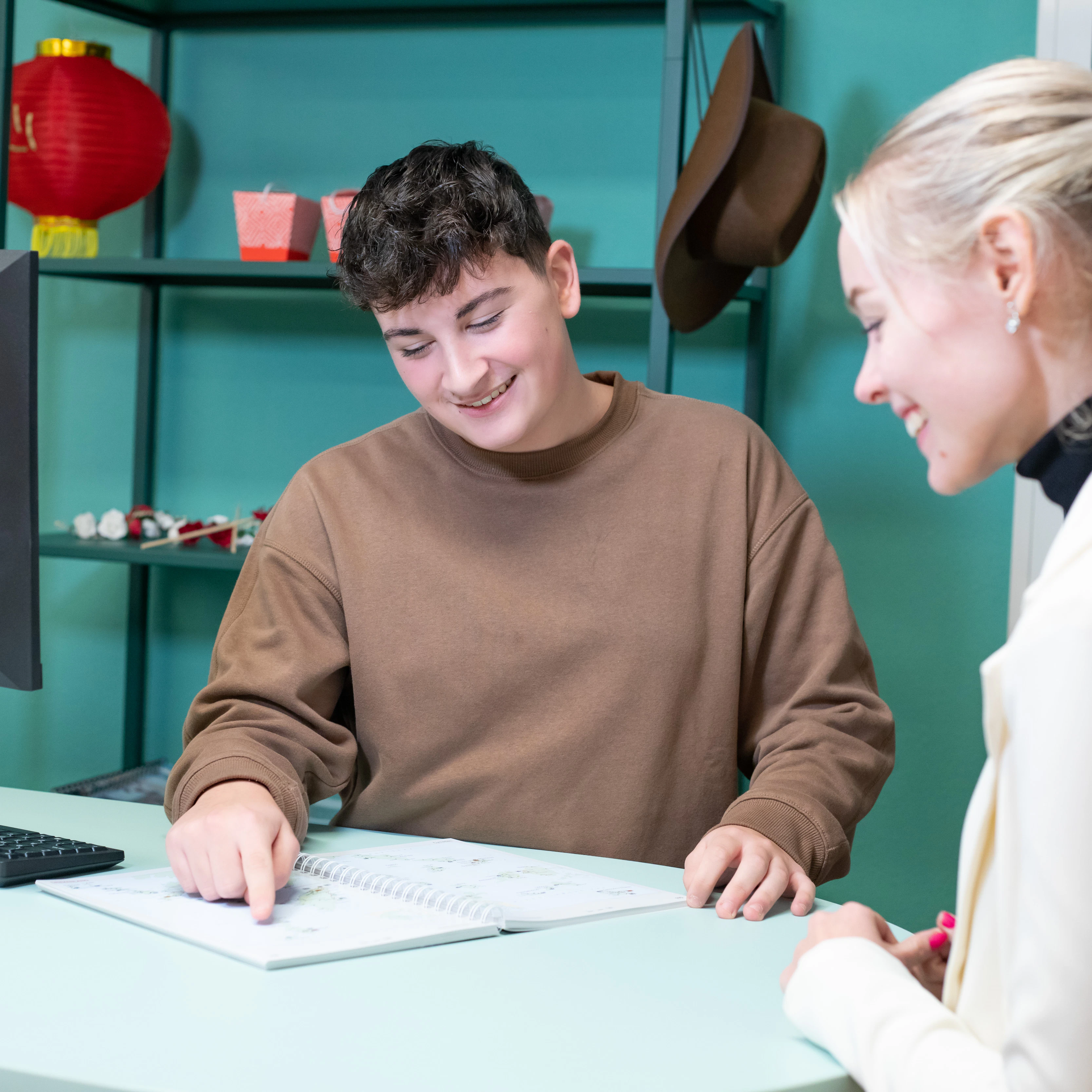 Student wijst op een papier terwijl een andere student toekijkt