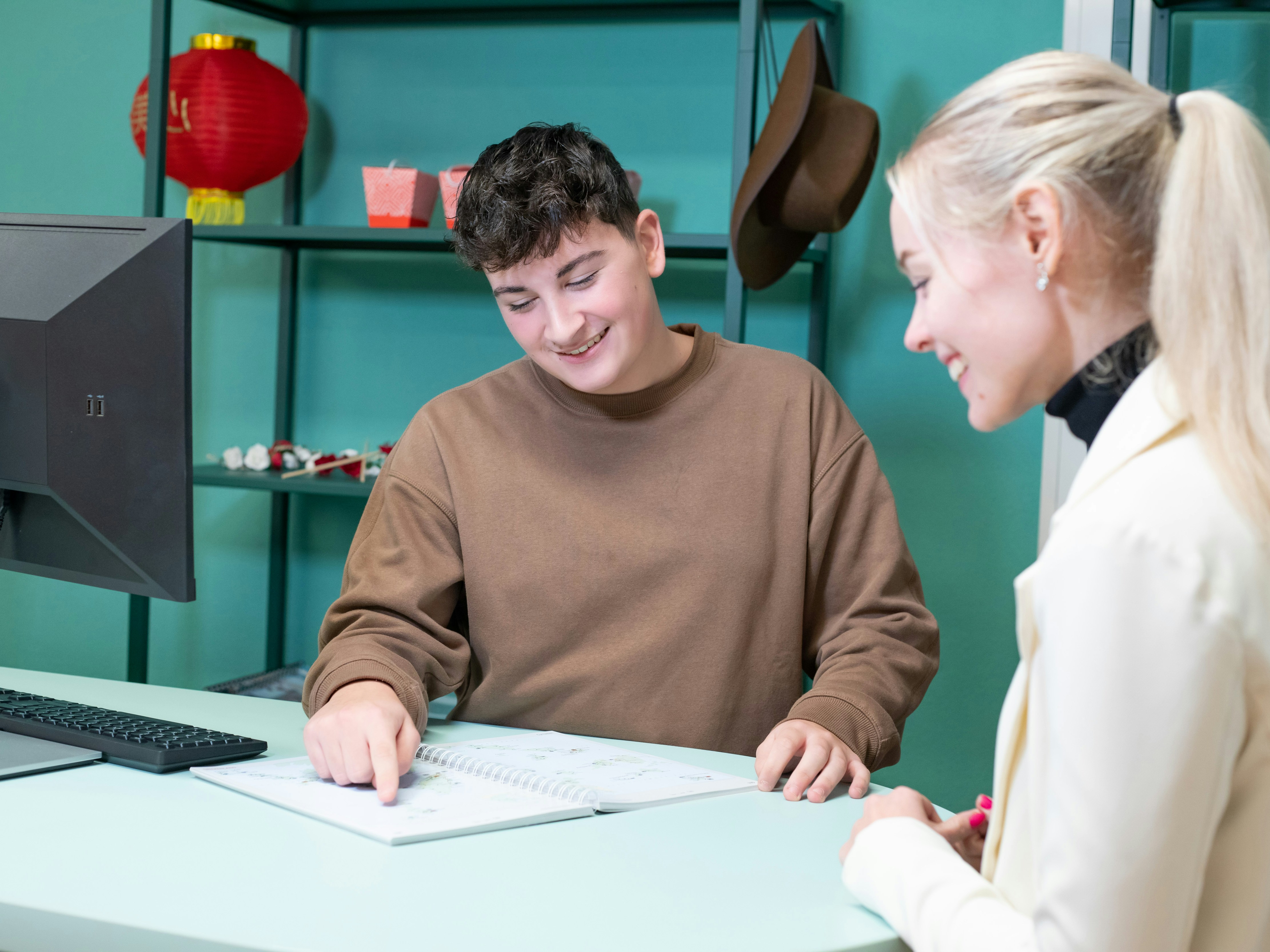 Student wijst op een papier terwijl een andere student toekijkt