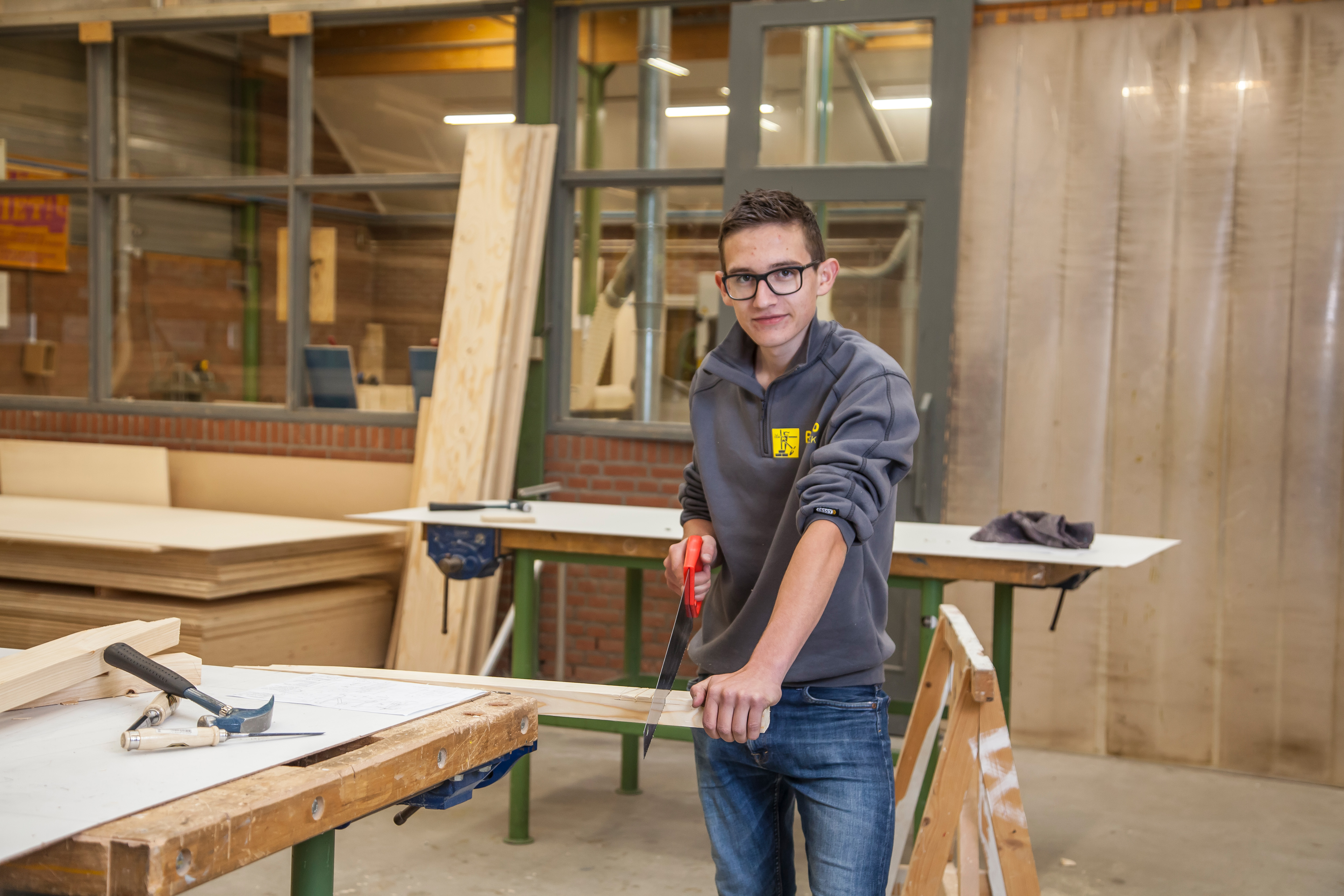 Jongen zaagt aan werkbank
