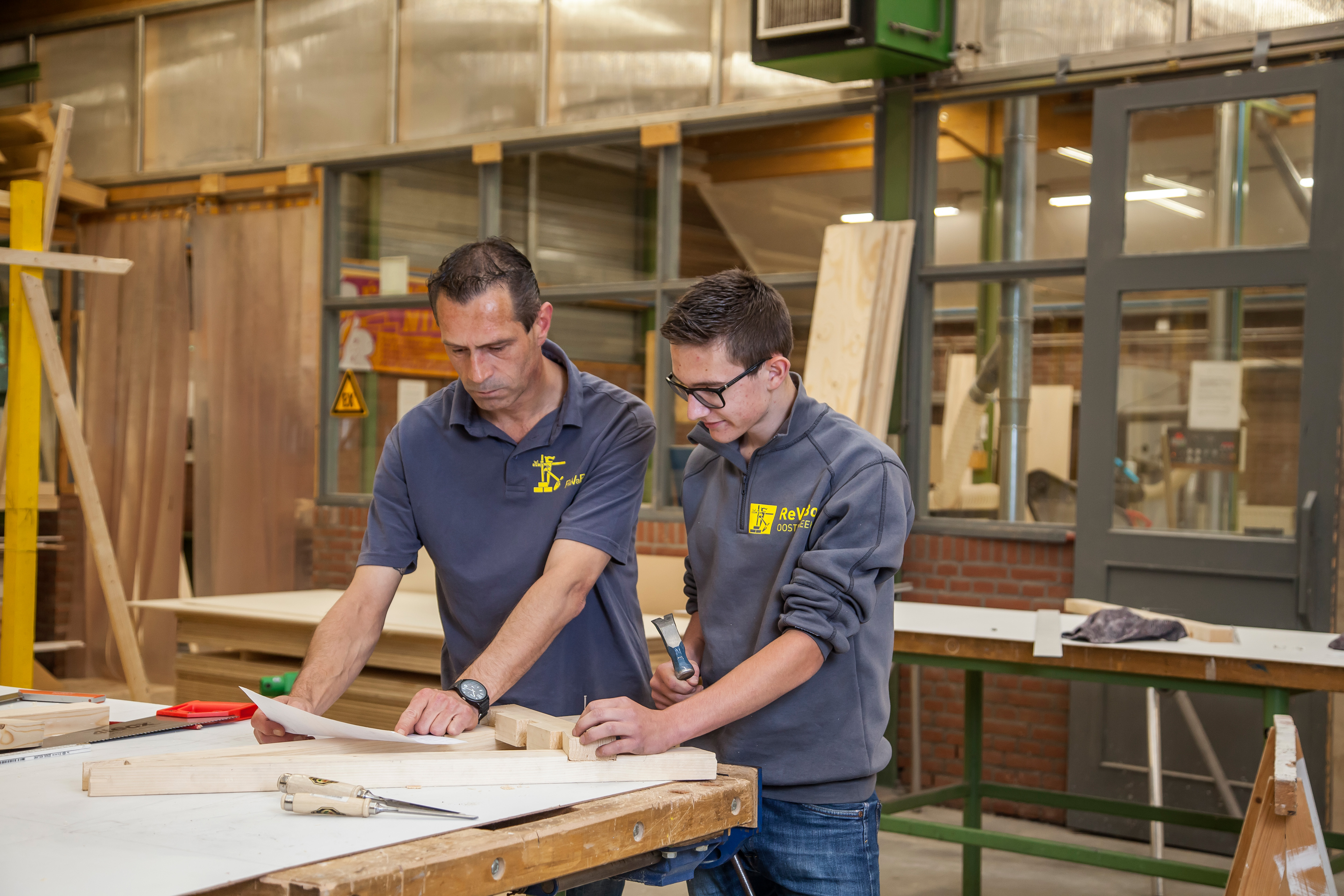 Student en docent samen aan het werk aan werktafel