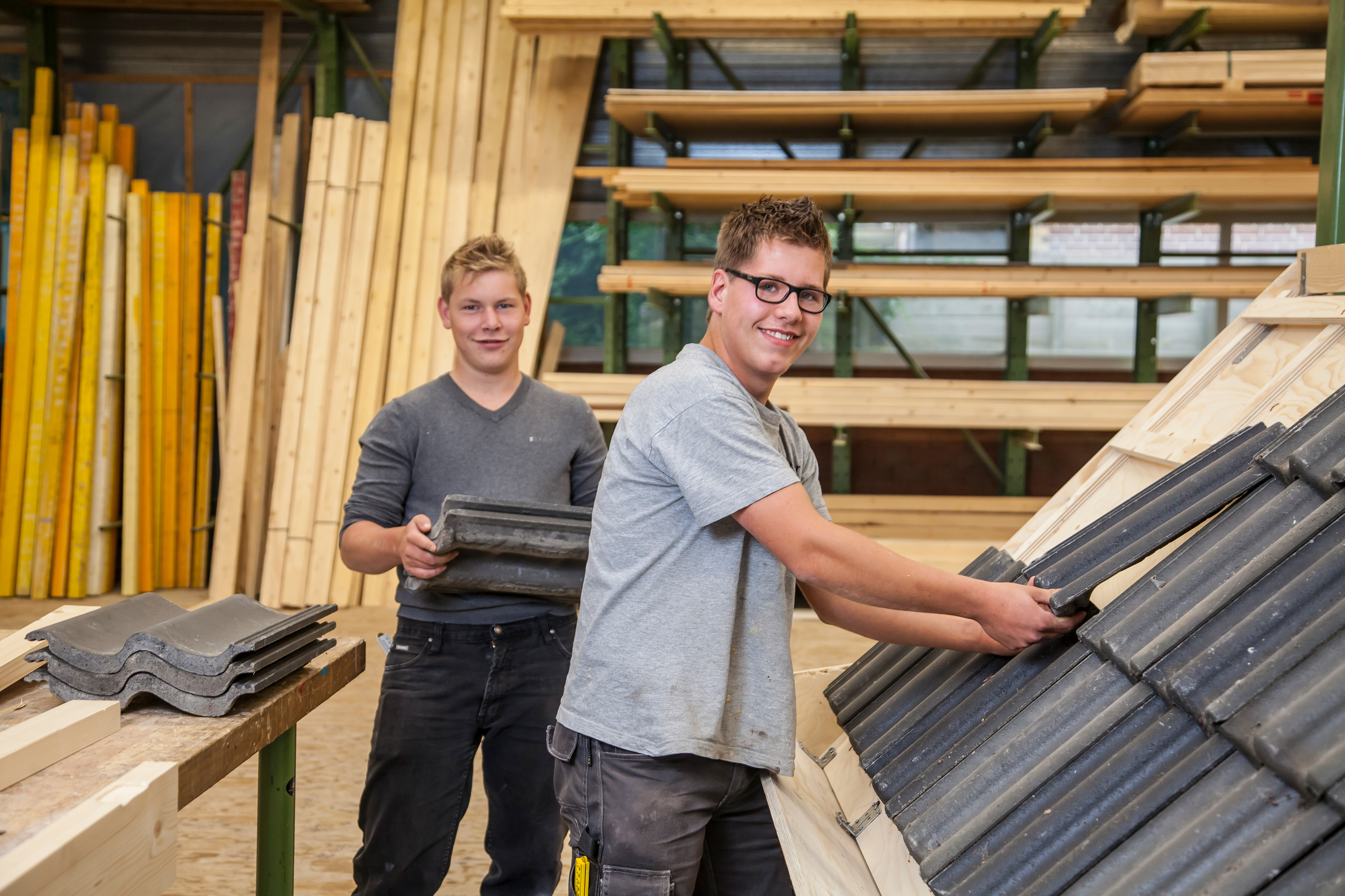Twee studenten leggen dakgoten op dak