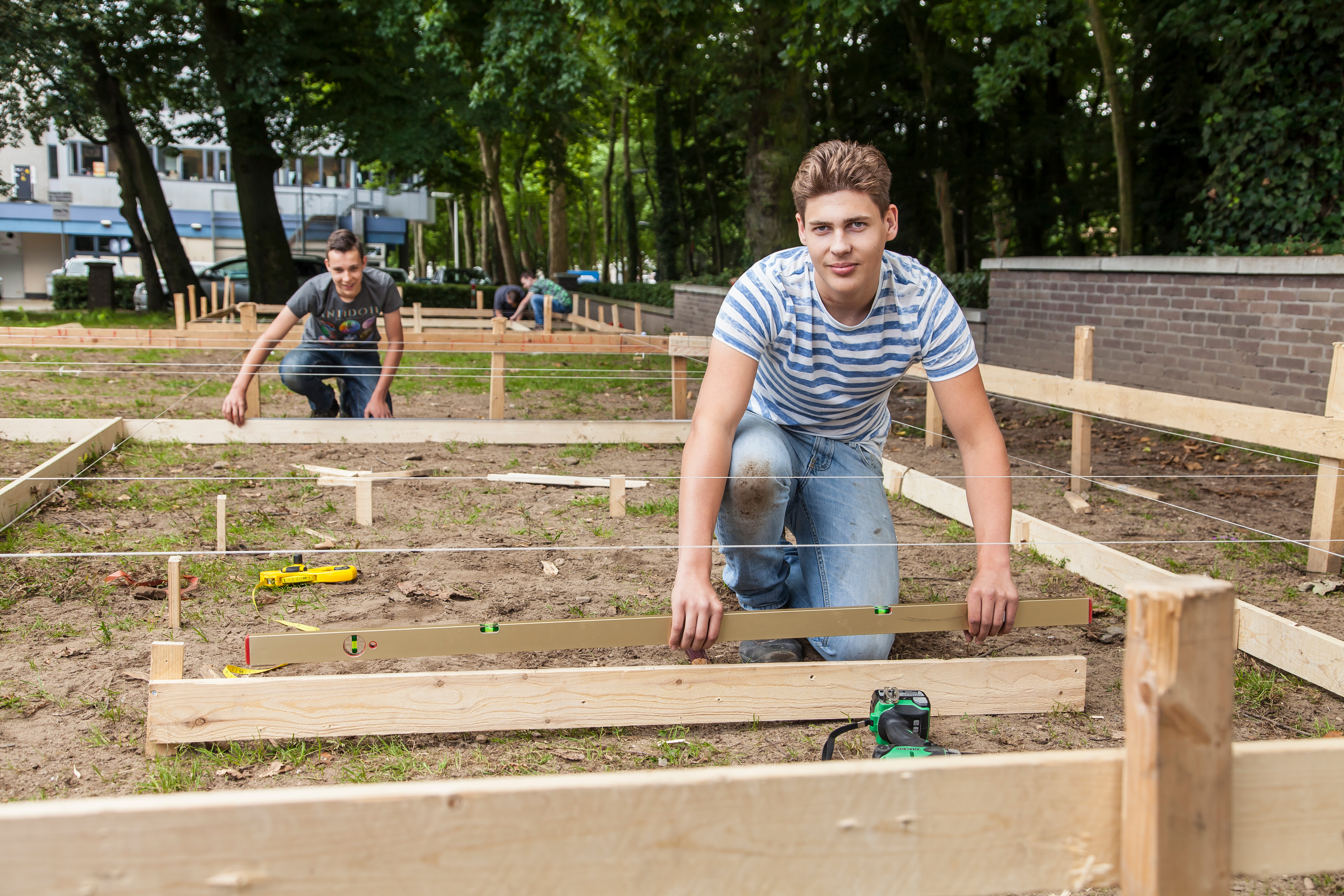 Student staat buiten en houdt houten plank vast