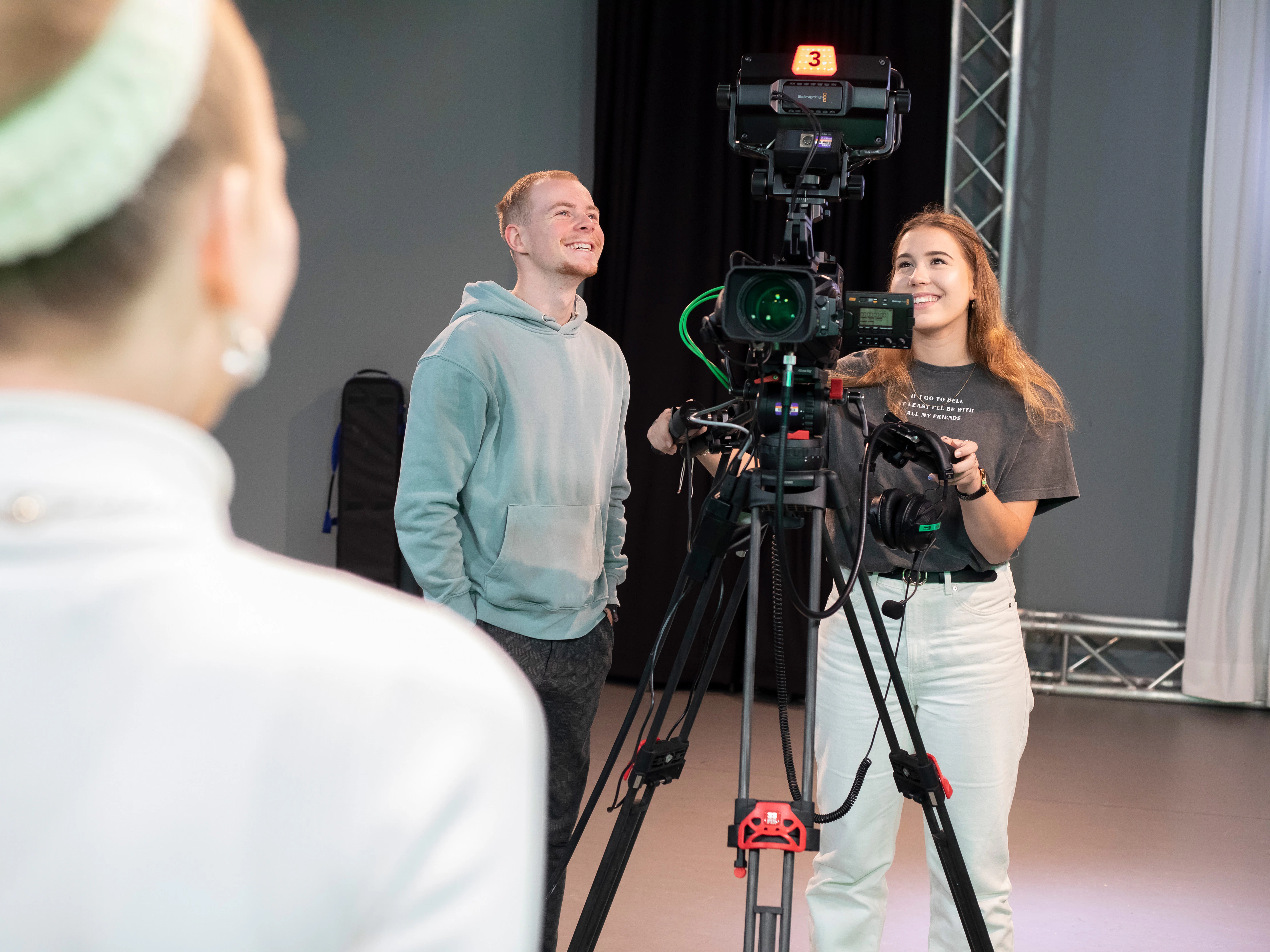2 studenten staan achter een camera
