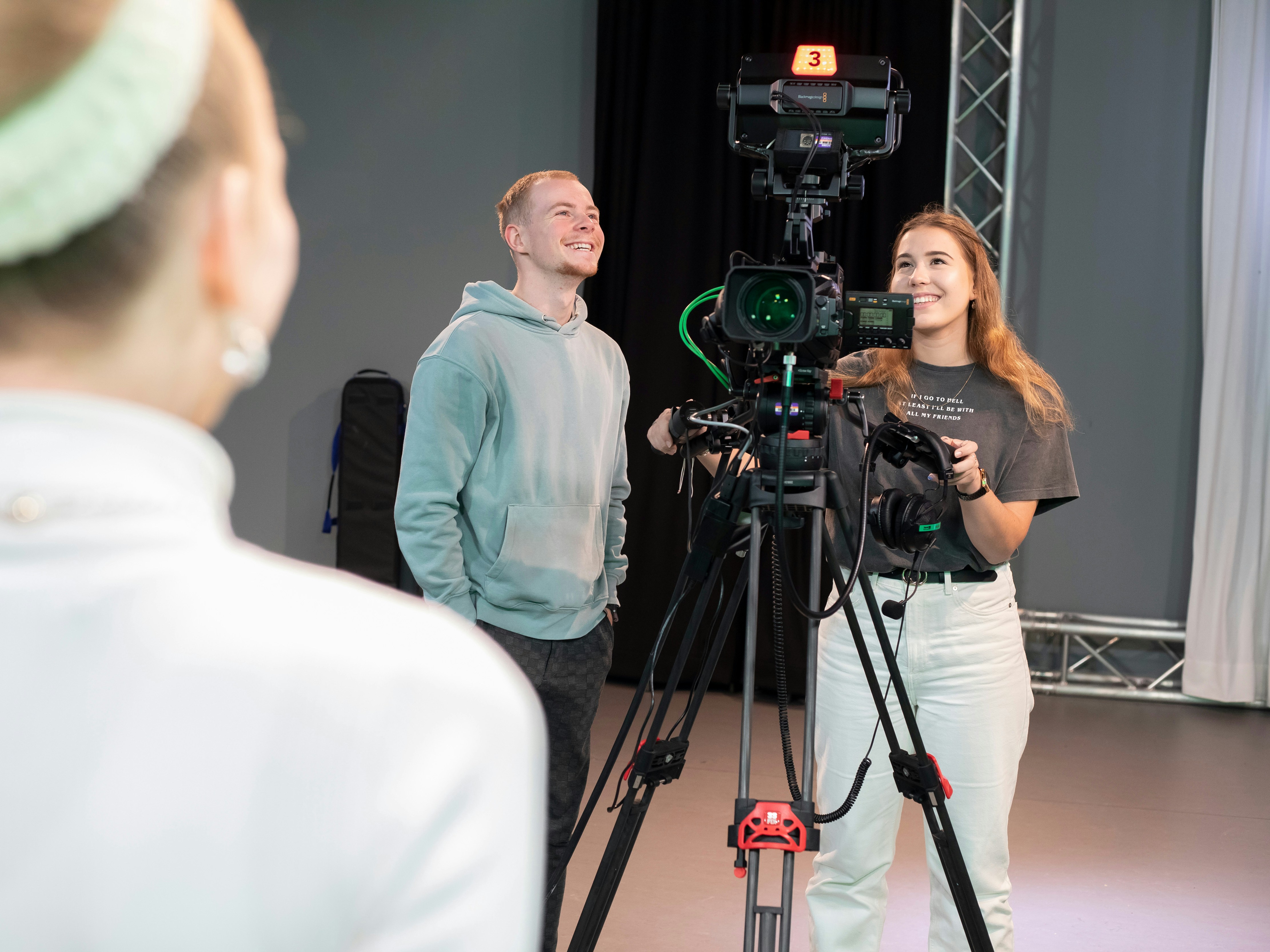 2 studenten staan achter een camera